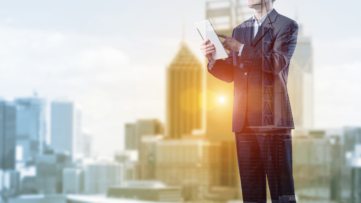 A city backdrop overlaid with a man on an ipad