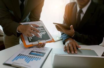 Two coworkers going over costs and data