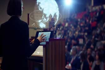 woman-speaking-at-podium-in-conference